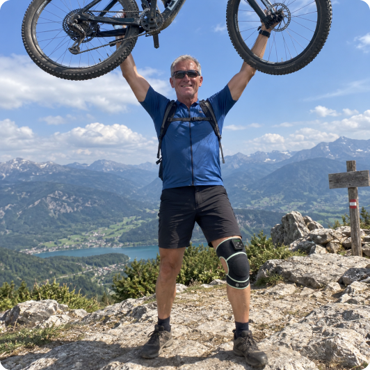 Kunde steht mit seinem Fahrrad auf dem Berg