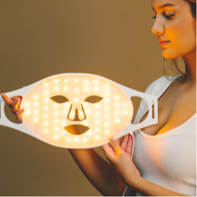 Frau betrachtet gelbes Licht der LED Maske