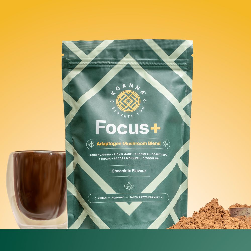 Zeigt die grüne, wiederverschließbare Verpackung von Focus+, daneben das braune Pulver mit Messlöffel und dahinter eine Tasse mit dem schokoladigen Getränk.