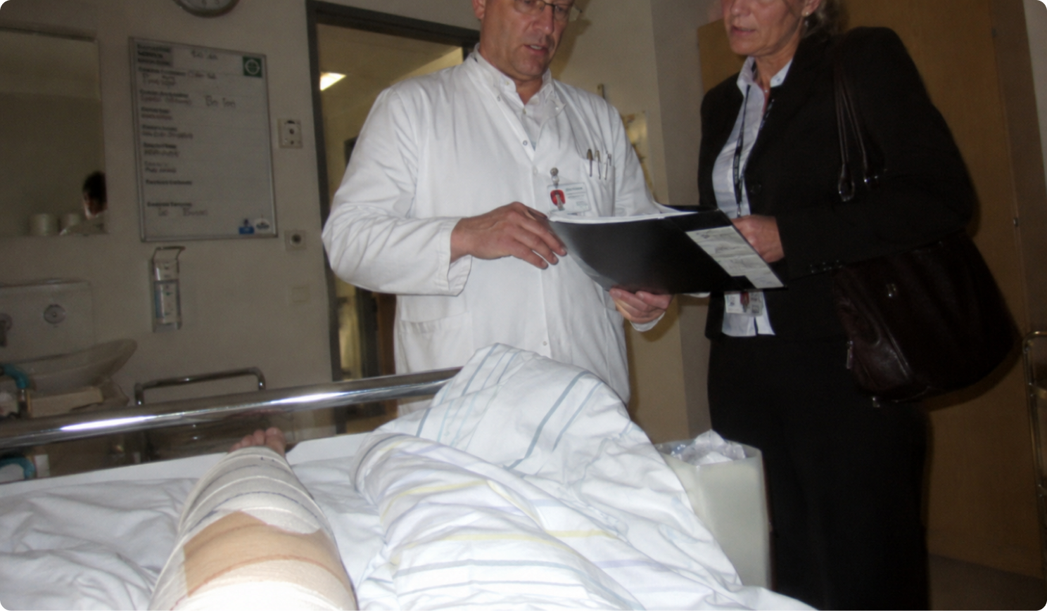 Patientin nach der Knie-OP im Gespräch mit ihrem Arzt